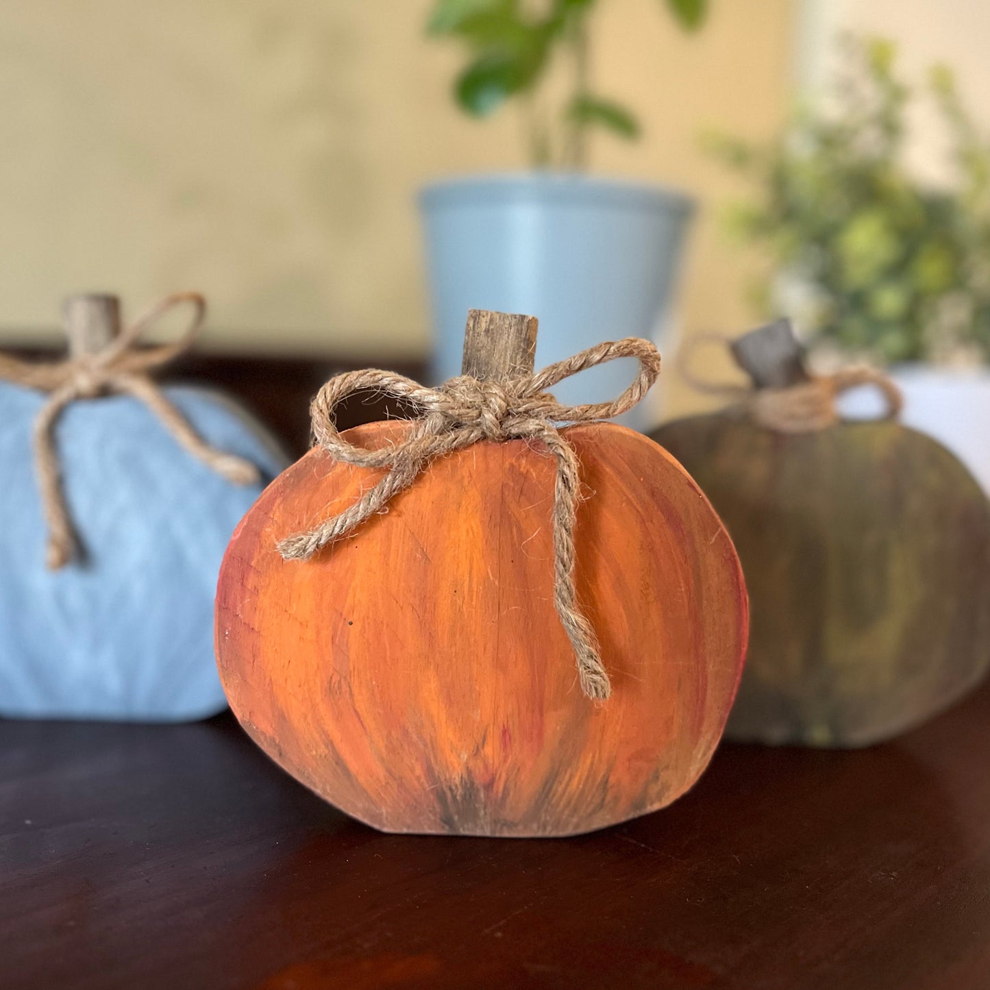 Decorative pumpkins with twine on a wooden surface